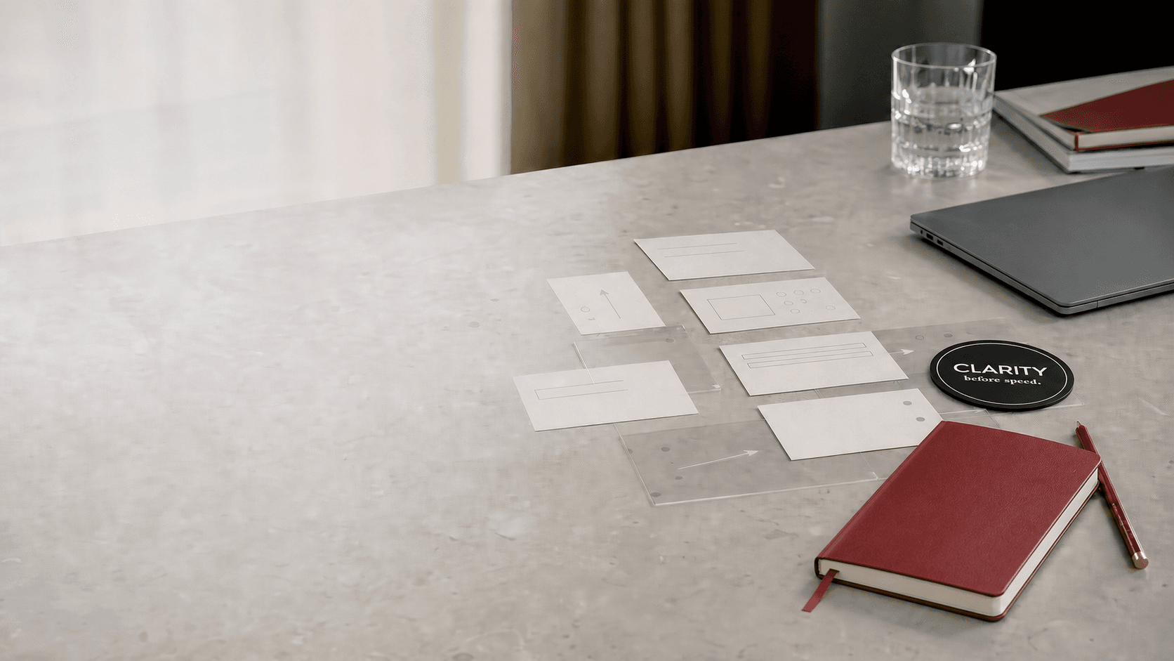 A working session on process design: sequencing cards, a red notebook and a Clarity before speed marker on a stone table